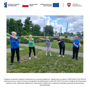 Pięć uczestniczek zajęć na trawniku przed świetlicą w Jasinie wykonuje ćwiczenia ruchowe w postawie stojącej. 