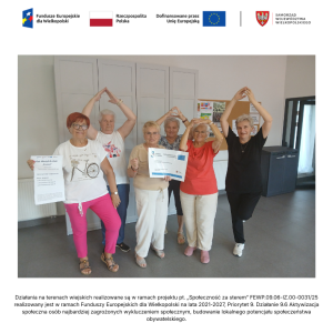 Sześć seniorek pozuje do zdjęcia w świetlicy wiejskiej w Jasinie. Dwie z nich trzymają w rękach plakaty. Cztery pozostałe wykonują piątą pozycję baletową.