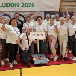 Zdjęcie przedstawia grupę swarzędzkich seniorów podczas olimpiady dla seniorów w Luboniu. Zdjęcie wykonano na sali gimnastycznej.