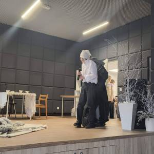 Trwa spektakl na scenie w Centrum Aktywności Seniora. Aktorzy odgrywają jedną ze scen.