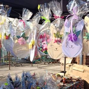 Zdjęcie przedstawia wiszące ozdoby wielkanocne w postaci kolorowych, bogato ozdobionych zajęczych głów.