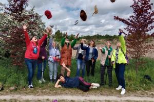 Grupa trekkingowa w Dolinie Cybiny. Wszystkie uczestniczki wyrzucają w górę swoje kapelusze i czapki.