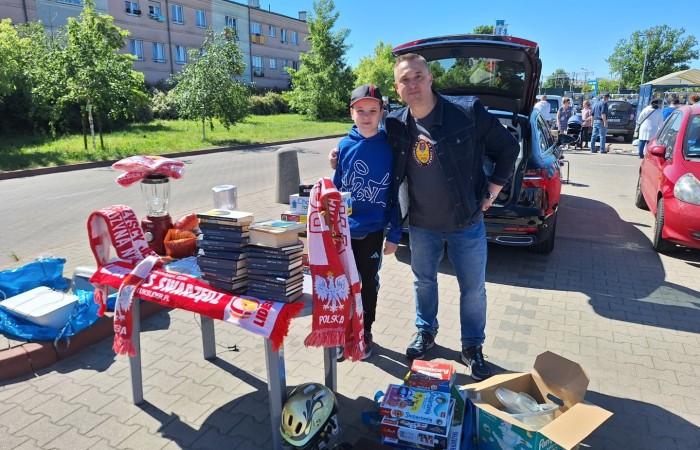 mezdzyzna wraz z dzieckiem sprzedają szaliki z napisem polska