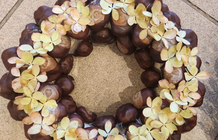 Zdjęcie ukazuje wyrób artystyczny stworzony z kwiatów i kasztanów